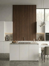 Tall walnut WPC fluted 3D accent wall behind a white modern kitchen island