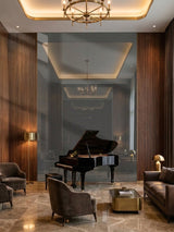 Large gray mirror wood veneer panel behind a grand piano in an elegant wood-paneled lounge