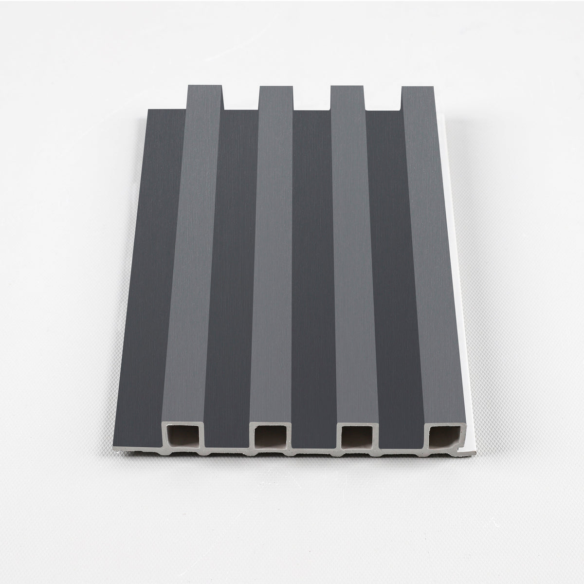 Silver gray metallic WPC fluted 3D wall panel sample with raised ribs and visible hollow cross-section