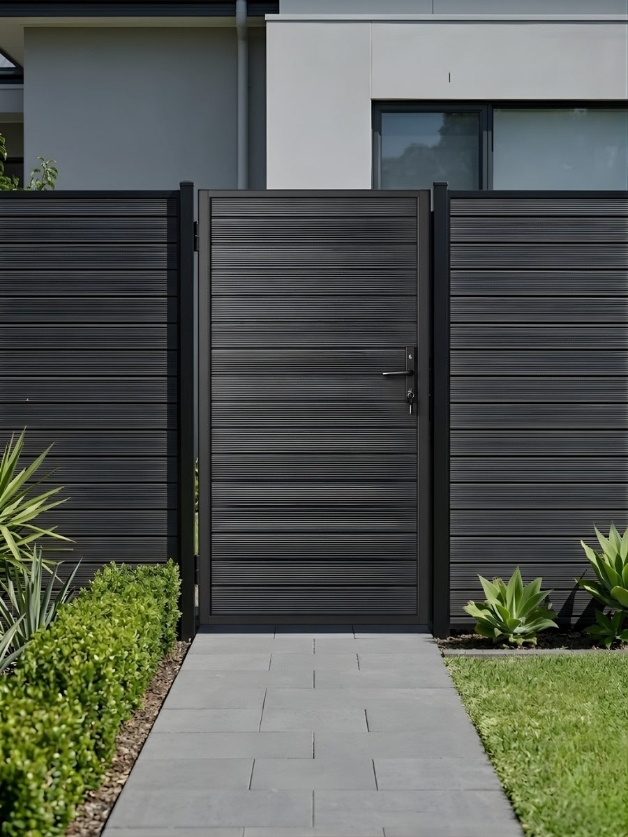4x6 aluminum privacy gate installed in a matching dark fence along a modern garden walkway