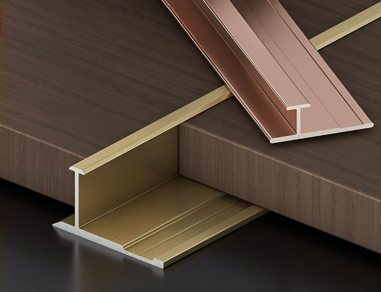 Gold and rose-gold aluminum H-joint trims displayed with dark wood-look PVC wall panels