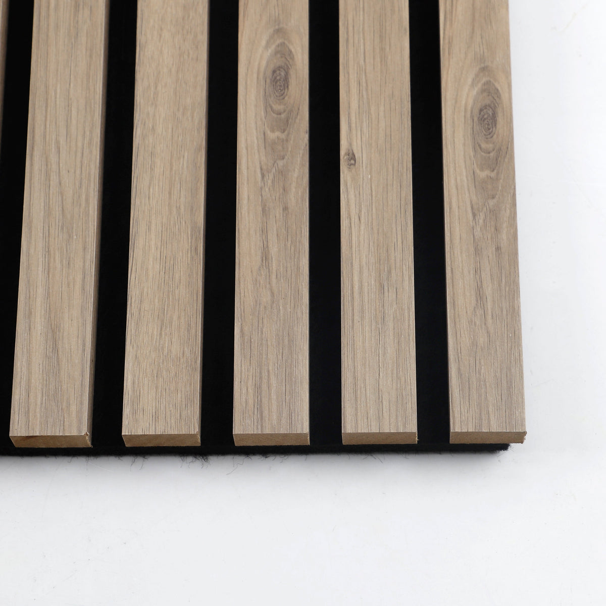 Close-up of five white oak veneered slats showing natural grain and black acoustic backing