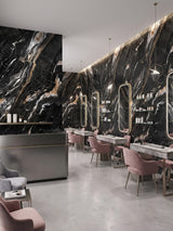 Contemporary salon with Doral Night marble PVC wall panels, illuminated mirrors, and pink chairs