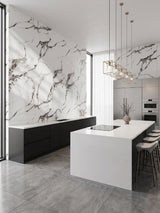 Modern kitchen with Beige Ibiza marble PVC wall panels behind black cabinets and a white island