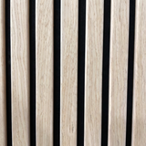 Close-up of oak wood grain slats with black acoustic backing between them
