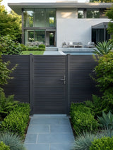 Dark aluminum full-privacy fence gate installed on a garden path leading to a modern home