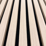 Close-up of natural oak wood grain slats and black acoustic backing