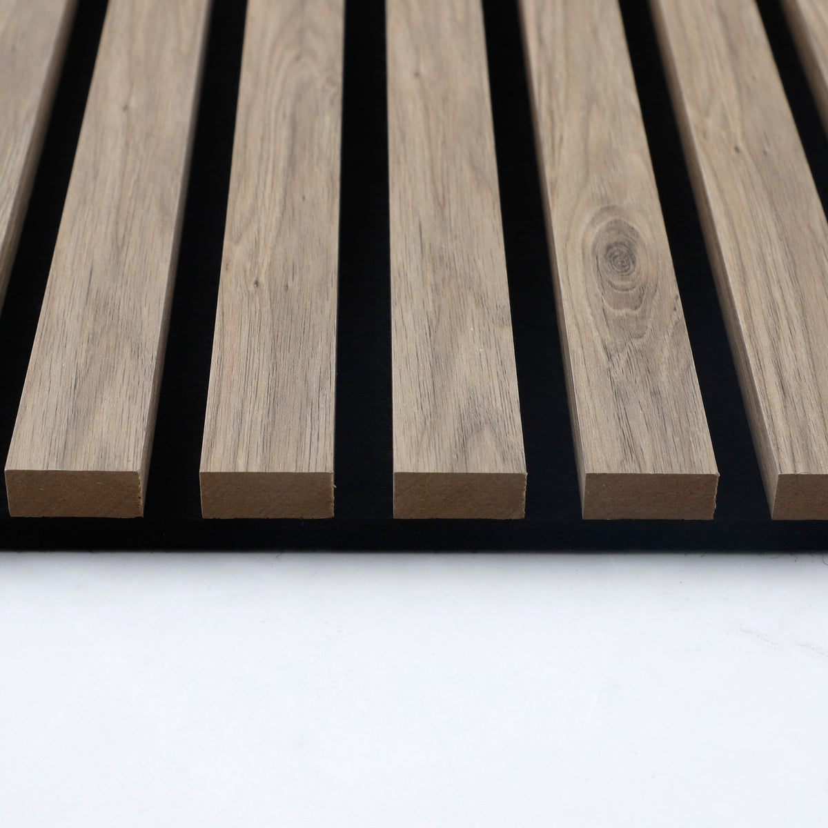 End view of white oak slat profiles and black backing on the acoustic wall panel