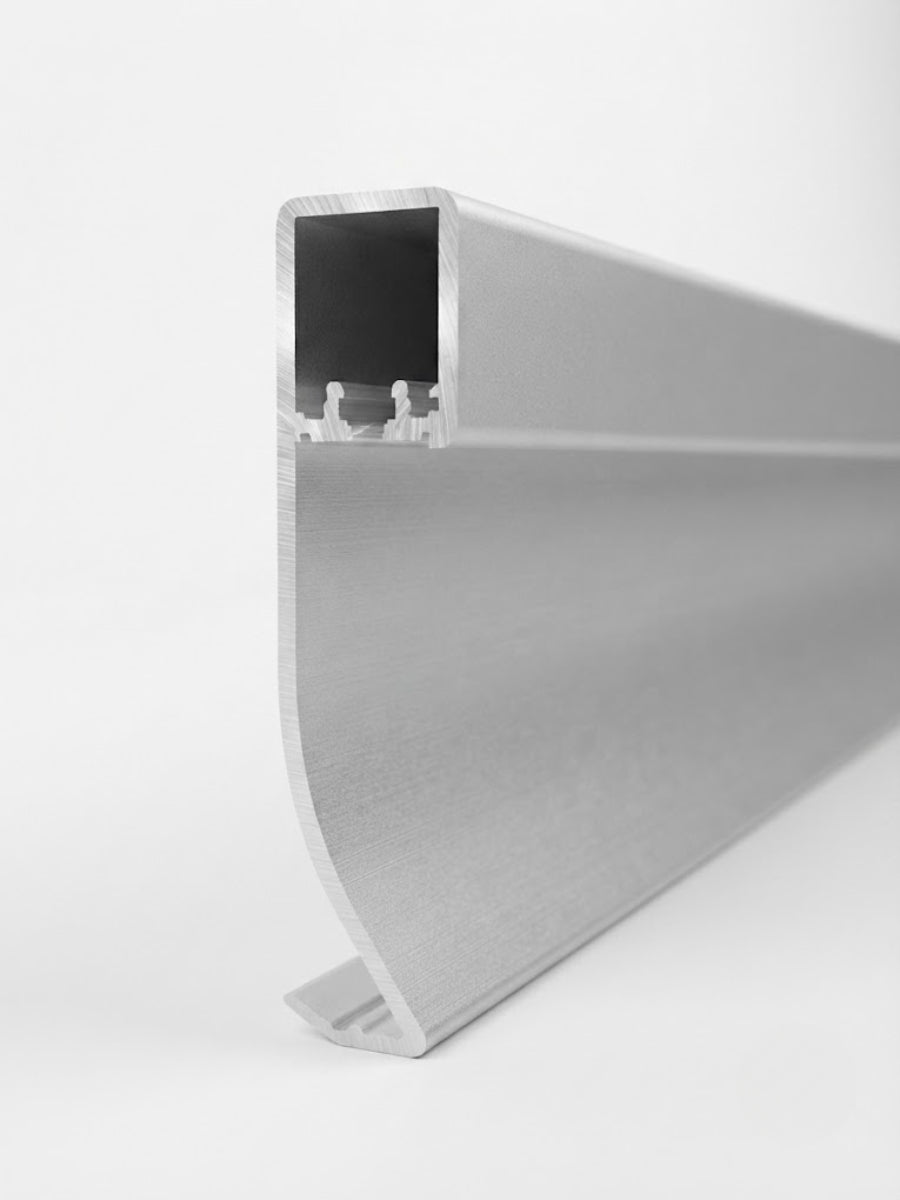 Close-up profile of premium white aluminum LED baseboard molding showing the hollow LED channel and curved base