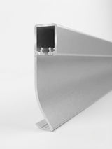 Close-up profile of premium white aluminum LED baseboard molding showing the hollow lighting channel and curved face