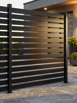 Black open slat aluminum fence panel installed beside a modern patio
