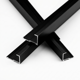 Three crossed black aluminum alloy end cap trim pieces showing the open ends