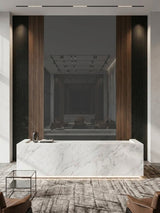 Gray mirror wood veneer panel set within a walnut and black fluted reception wall behind a marble desk