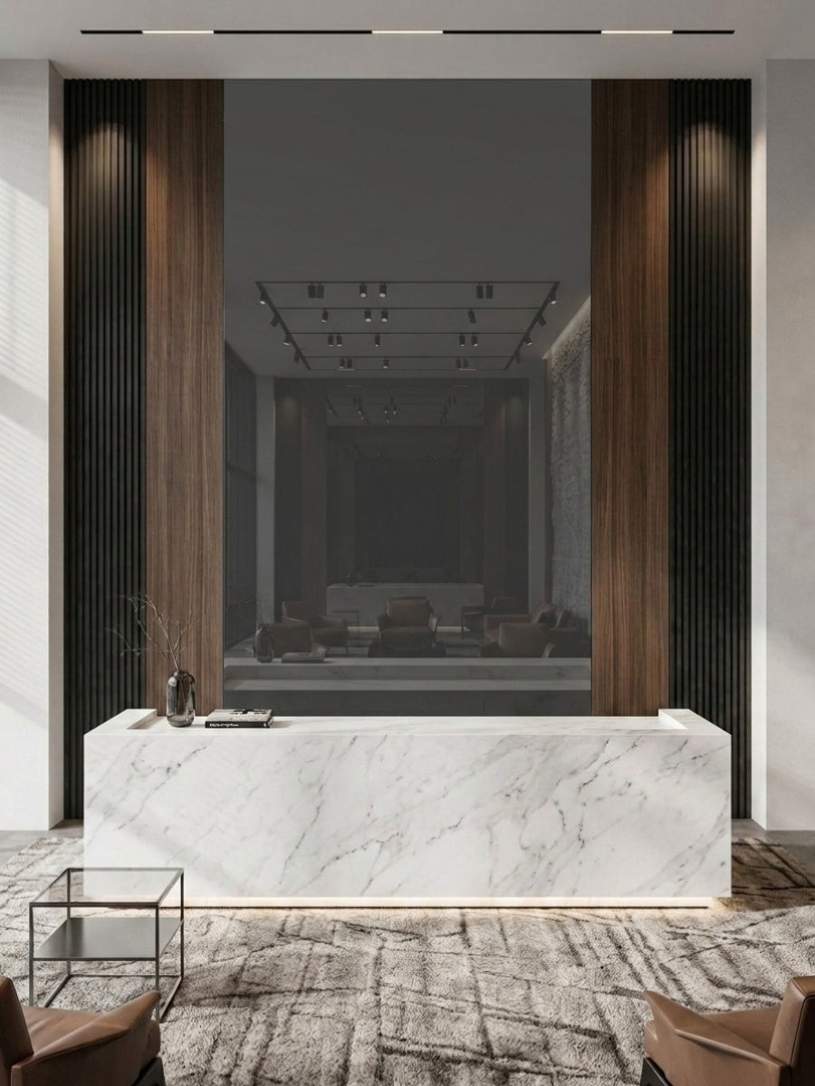 Gray mirror wood veneer panel set within a walnut and black fluted reception wall behind a marble desk