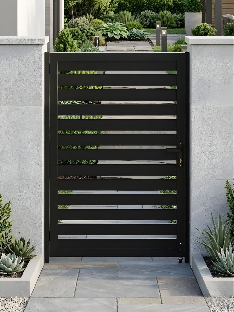 Black aluminum semi-privacy gate installed between white garden walls along a landscaped walkway