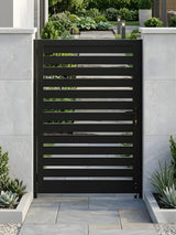 Black aluminum semi-privacy gate installed between white garden walls along a landscaped walkway