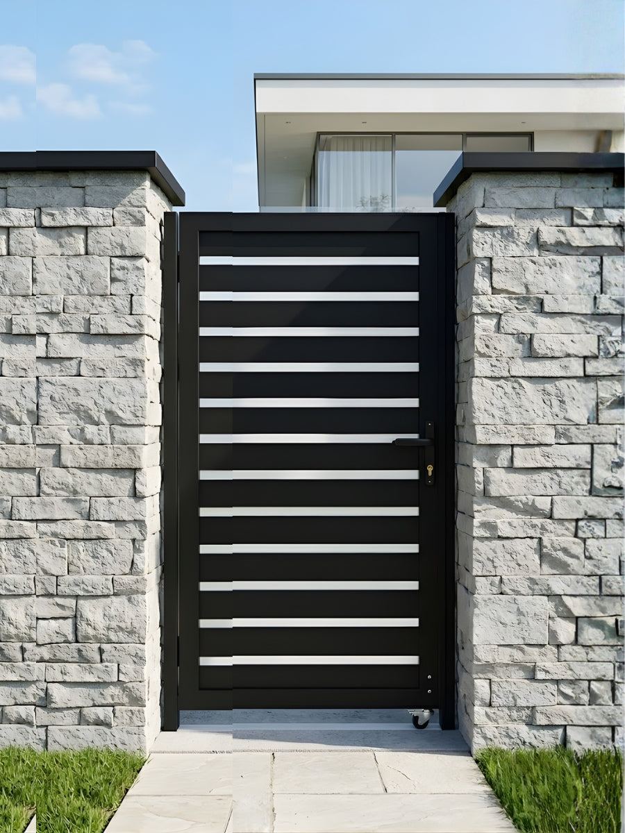 Modern black aluminum fence gate installed between stone walls at a home entrance