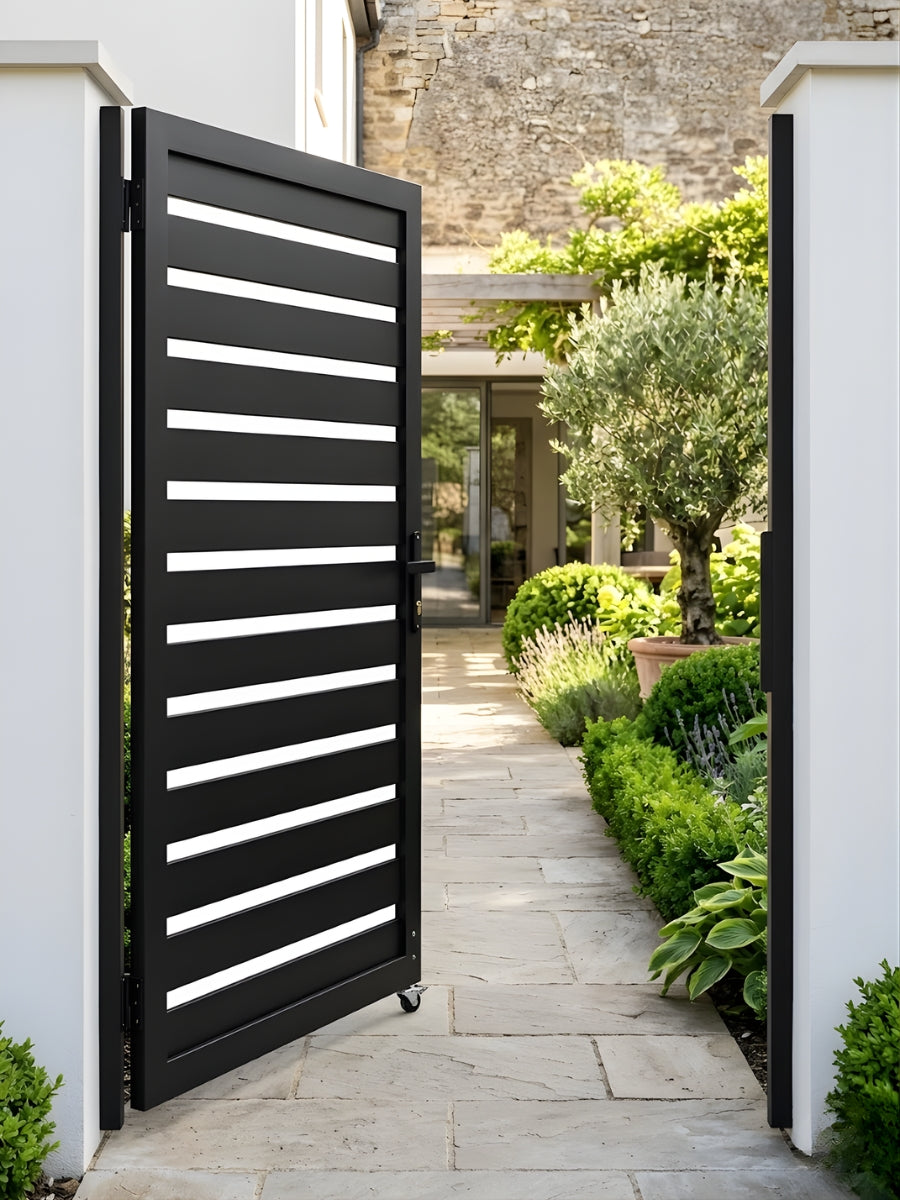 Open black aluminum semi-privacy gate installed at a landscaped garden walkway entrance