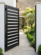 Open black aluminum semi-privacy gate installed at a landscaped garden walkway entrance