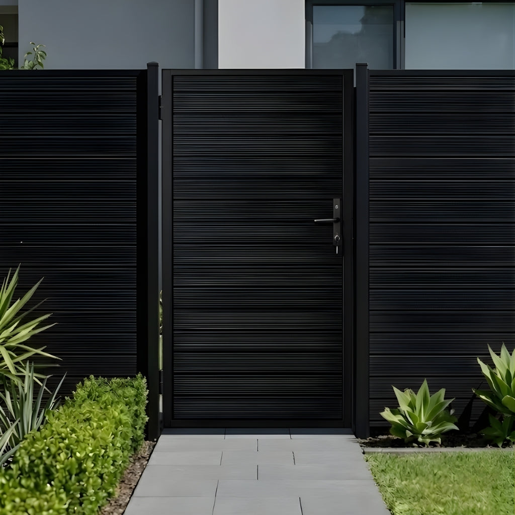 Front view of an installed dark aluminum full-privacy gate with matching fence and landscaped walkway