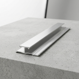 Silver aluminum seamless trim connector for wood veneer panels displayed on a gray concrete surface