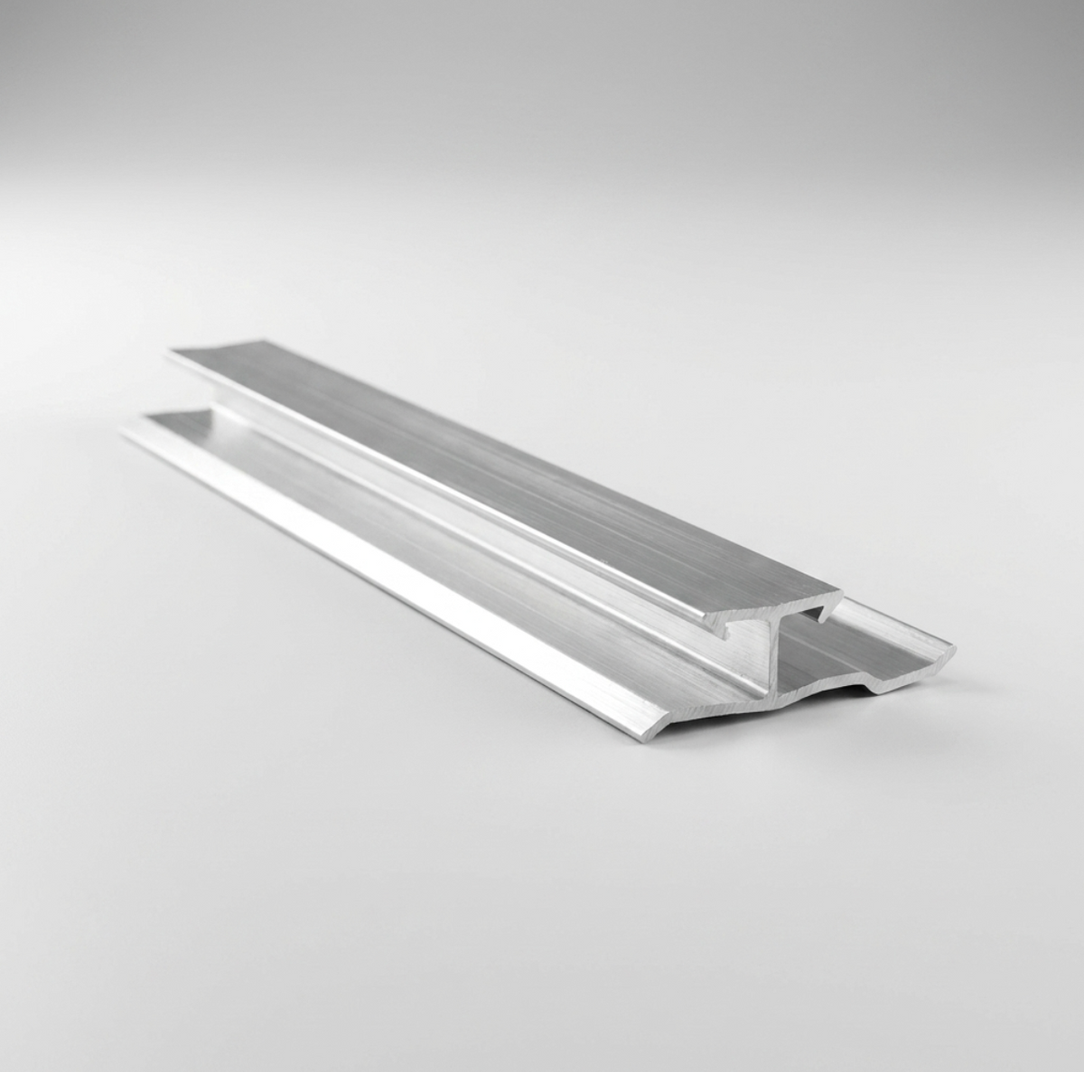 Angled view of an aluminum invisible trim connector showing the raised channel and wide side flanges