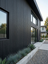 Black composite wide exterior cladding installed vertically on a modern home facade