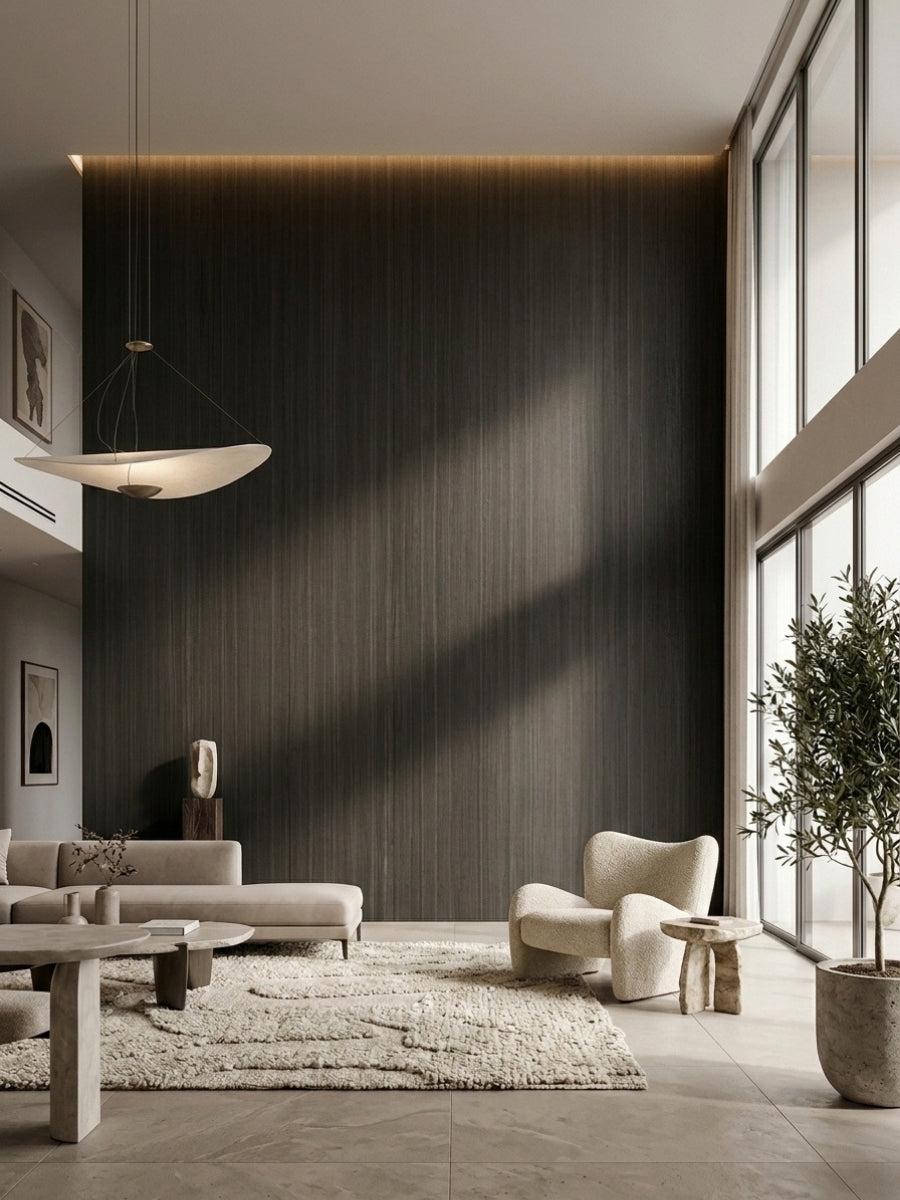 Floor-to-ceiling Blackwood veneer wall panels with vertical grain in a sunlit contemporary living room