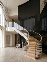 Black Mirror wood veneer panel finish on a dramatic curved staircase wall in a bright modern foyer