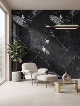 Black marble-look PVC wall panel with white veining behind a lounge chair, ottoman, and side table