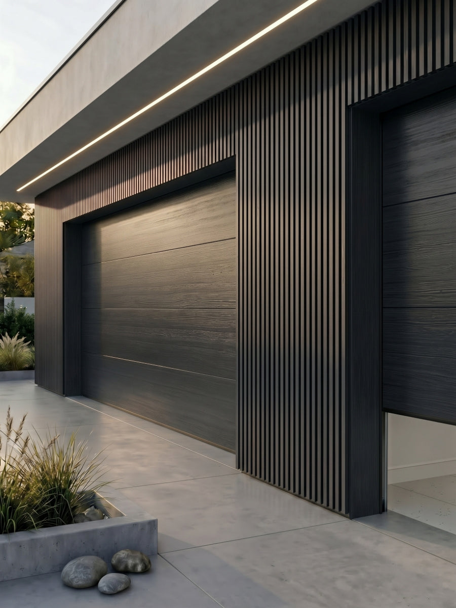 Wide gray and black composite cladding surrounding modern garage doors