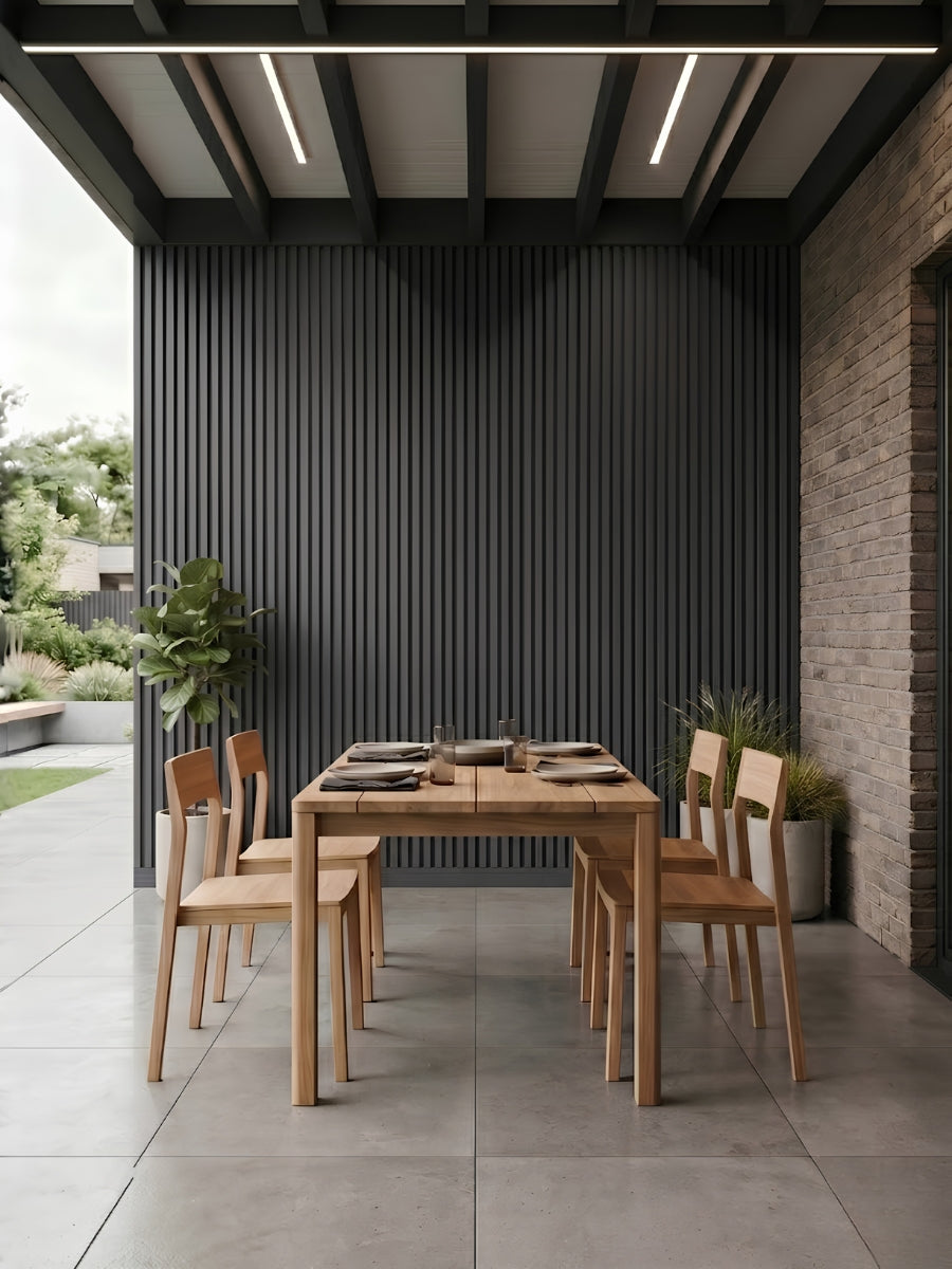 Gray and black composite exterior cladding installed behind a covered patio dining area