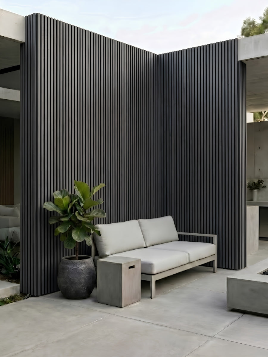 Wide gray and black composite cladding on tall courtyard walls beside outdoor seating