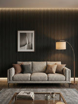 Blackwood WPC fluted 3D panels installed as a living room accent wall behind a gray sofa