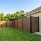 Walnut composite privacy fence and matching gate installed beside a house