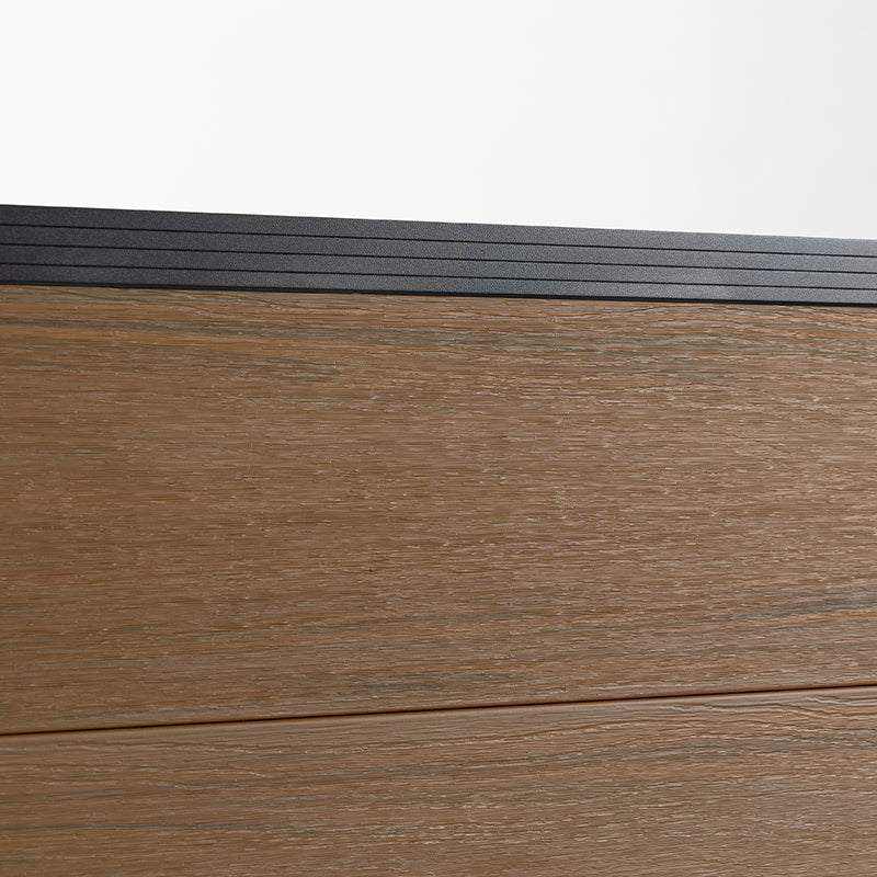 Walnut composite fence surface showing wood-grain texture and black top rail