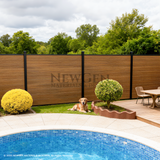 Walnut composite privacy fence beside a landscaped swimming pool patio