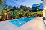 Walnut composite privacy fencing around a modern illuminated swimming pool