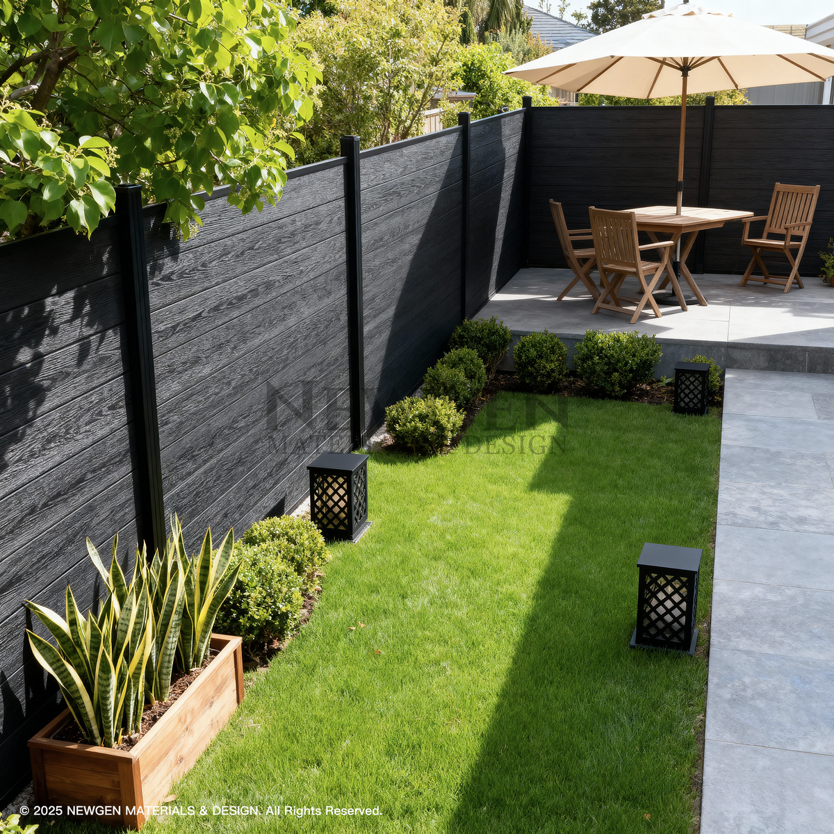 Black composite privacy fence installed around a landscaped garden dining area