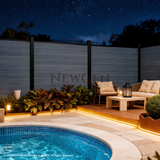 Light gray co-extrusion composite fence beside an illuminated poolside lounge at night