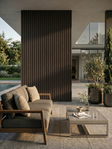 Dark brown composite cladding accent wall in a covered outdoor lounge with seating and potted plants