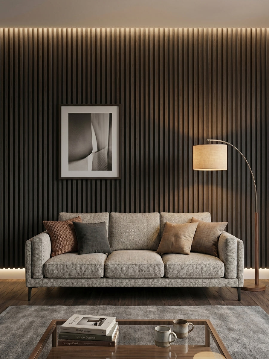 Dark Smoky Oak fluted wall panels behind a gray sofa with framed art and warm lighting