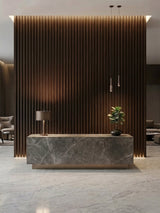 Reception desk set against a floor-to-ceiling Dark Walnut Oak WPC fluted 3D wall with warm lighting