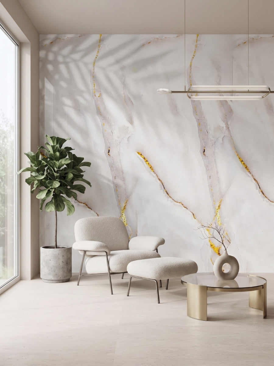Empress Gold PVC marble sheets with gray and gold veining on a lounge wall beside an armchair and plant