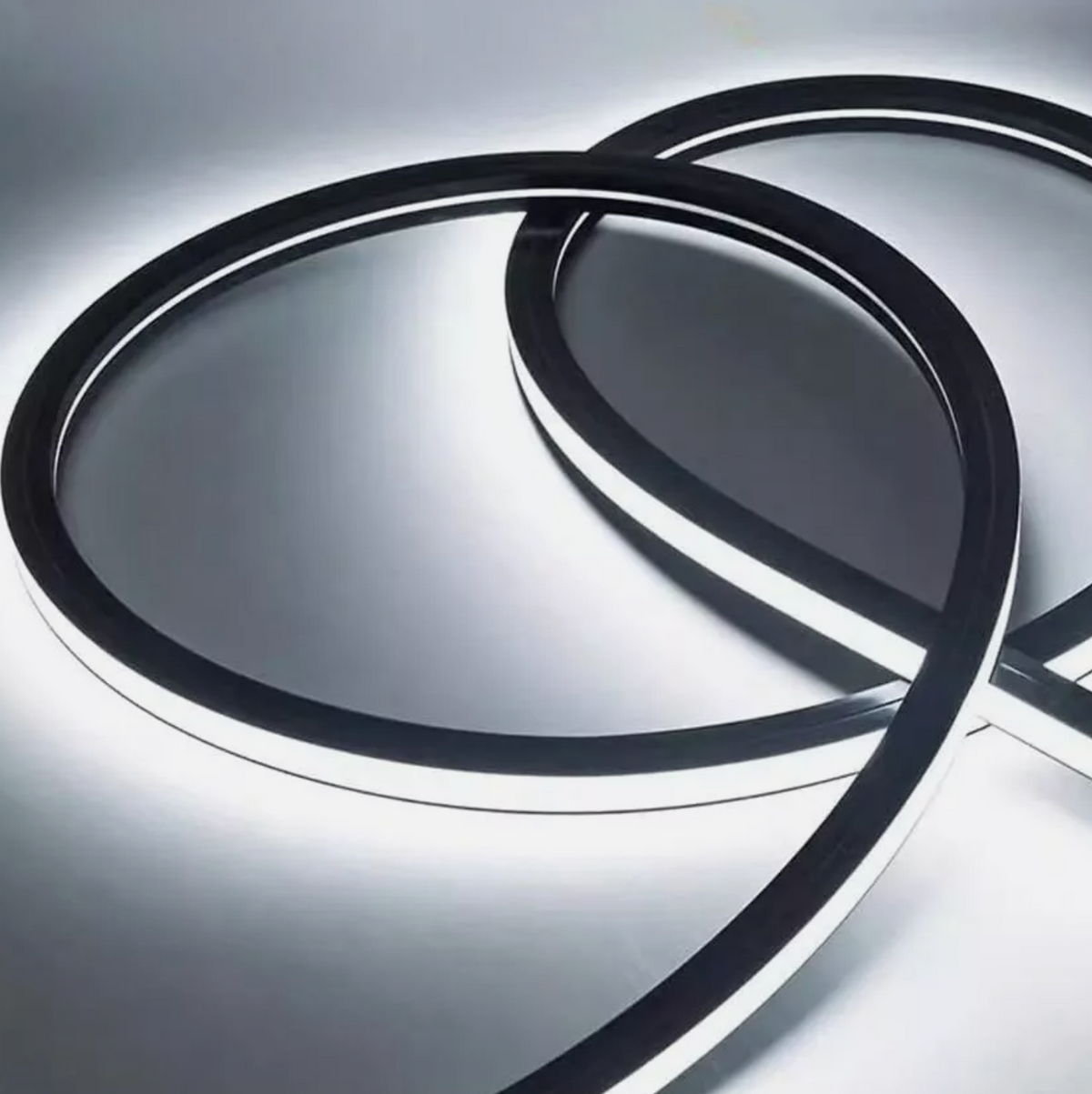 Flexible white LED light strip glowing in loose overlapping loops