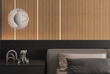 Warm vertical LED light strips accenting wood-look acoustic wall panels above a bedroom headboard