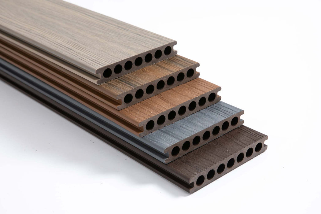 Stack of grooved mahogany composite deck boards in light