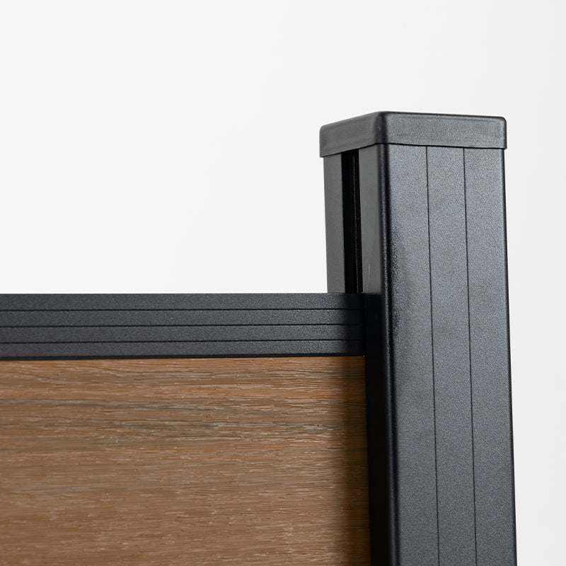 Close-up of black capped post and top rail on walnut composite fencing