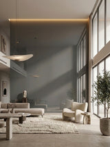 Bright living room with a large gray mirror wood veneer panel wall reflecting windows and neutral furniture
