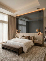 Gray mirror wood veneer panels forming a reflective accent wall behind a modern upholstered bed